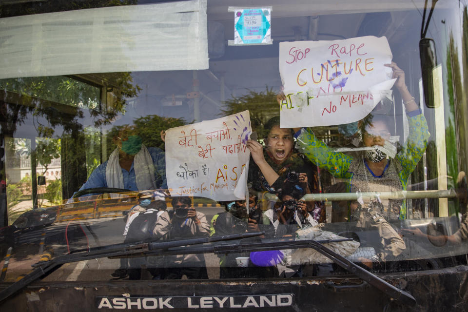 Indian activists hold placards and shout slogans from inside a bus after being detained during a protest in New Delhi, India, Wednesday, Sept. 30, 2020. The gang rape and killing of the woman from the lowest rung of India's caste system has sparked outrage across the country with several politicians and activists demanding justice and protesters rallying on the streets. (AP Photo/Altaf Qadri)