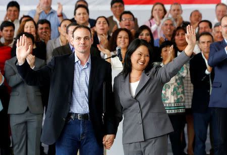 Peruvian presidential candidate Keiko Fujimori, accompanied by her husband Mark Villanella and elected congressmen, waves to the media after Peru's electoral office ONPE said she lost against Pedro Pablo Kuczynski in the country's presidential election, at her party's headquarters in Lima, Peru, June 10, 2016. REUTERS/Mariana Bazo