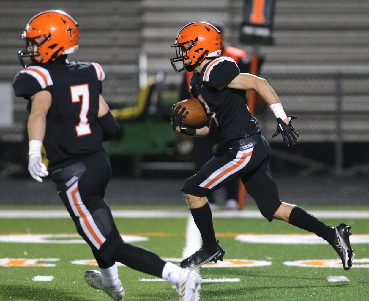 Mason Ashby, right, of Hoover picks up yardage as AJ Dolph, 7, leads the way during their first round playoff game against Licking Heights at Hoover on Friday, Oct. 28, 2022. 