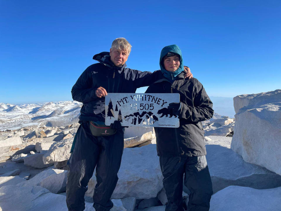 Thijs Koekkoek and his son hold a sign with the text: 