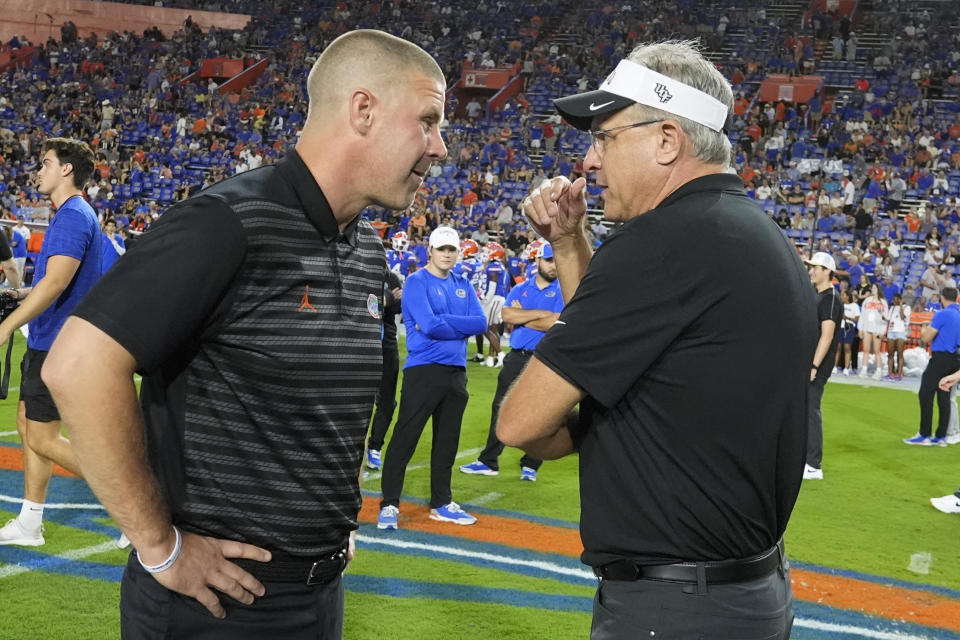 Florida head coach Billy Napier, left, and UCF head coach Gus Malzahn greet each other before an NCAA college football game, Saturday, Oct. 5, 2024, in Gainesville, Fla. (AP Photo/John Raoux)