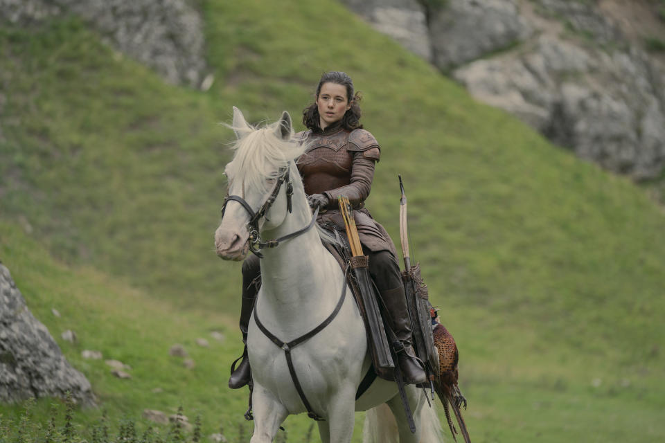Rhea Royce in bronze armor on horseback in the Vale