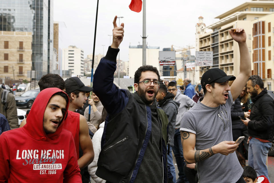 Anti-government protesters chant slogans as they block a main highway by garbage containers in Beirut, Lebanon, Friday, Jan. 17, 2020. Protesters closed major roads in the capital Beirut and around wide parts of Lebanon paralyzing the country as the political crisis over the formation of a new government worsens. (AP Photo/Bilal Hussein)