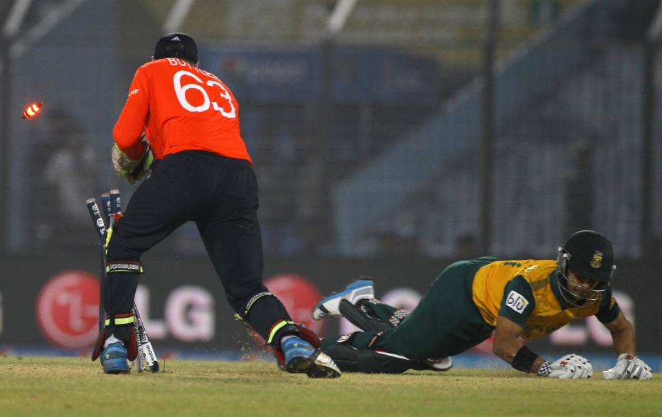 England's wicketkeeper Jos Buttler, left, successfully breaks the wickets to dismiss South Africa's JP Duminy, right, during their ICC Twenty20 Cricket World Cup match in Chittagong, Bangladesh, Saturday, March 29, 2014. (AP Photo/A.M. Ahad)