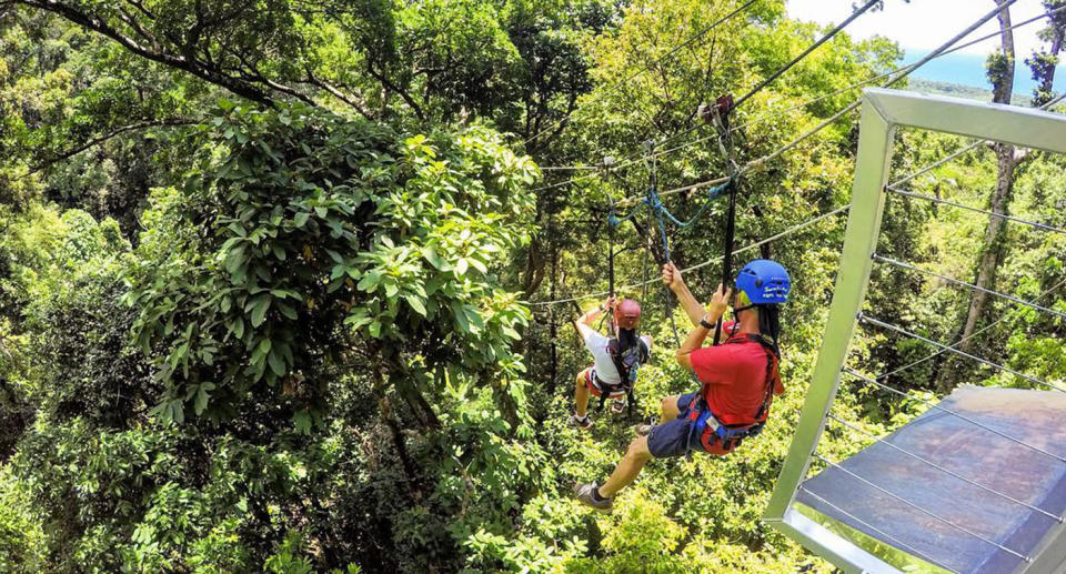 Two unknown people on a zipline from Jungle Surfing Canopy Tours Facebook page.