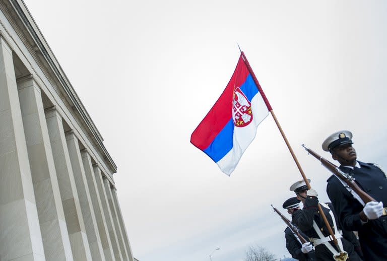 Guards are seen marching with the Serbian flag after the arrival of Serbia's Minister of Defense Aleksandar Vucic during a honor cordon at the Pentagon, on December 6, in Washington, DC