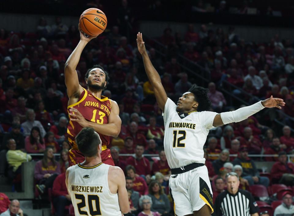 Iowa State's Jaren Holmes (13) takes a shot around Milwaukee's Vincent Miszkiewicz (20) and guard Kentrell Pullian (12) during the first half at Hilton Coliseum on Sunday.