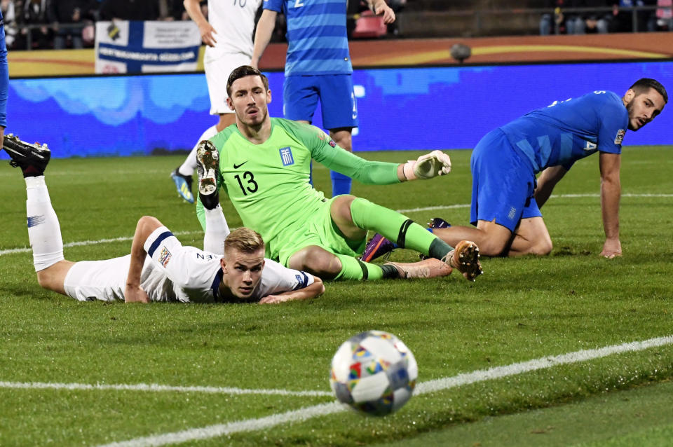 Jasse Tuominen of Finland, left, and Greece's goalkeeper Vassilis Barkas and Kostas Manolas, right, during the UEFA Nations League football match between Finland and Greece in Tampere, Finland, on Monday, Oct. 15, 2018. (Heikki Saukkomaa/Lehtikuva via AP)