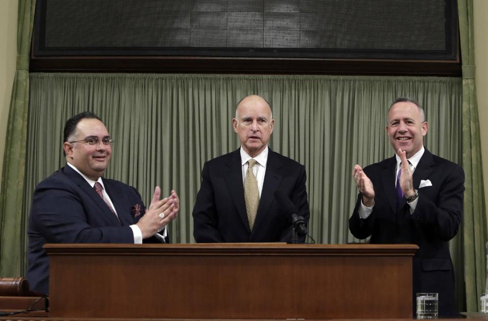Gov. Jerry Brown, center, receives applause from legislative leaders, Assembly Speaker John Perez, D-Los Angeles, left, and Senate President Pro Tem Darrell Steinberg, D-Sacramento, before he delivers his State of the State address at the Capitol in Sacramento, Calif., Wednesday, Jan. 22, 2014. Brown delivered a dual message in his annual address to the Legislature, that a California resurgence is well underway but is threatened by economic and environmental uncertainties.(AP Photo/Rich Pedroncelli, pool)