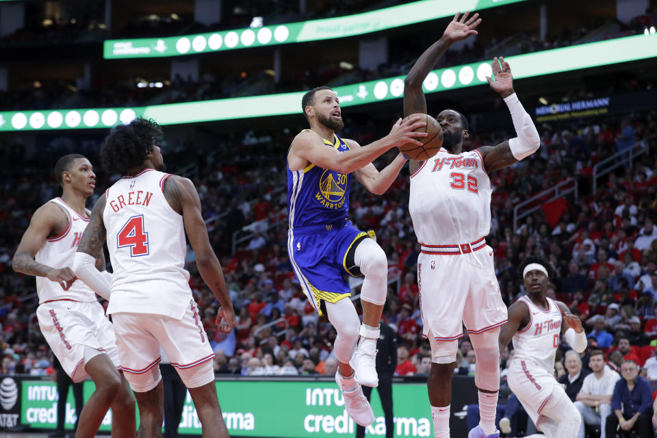 Golden State Warriors guard Stephen Curry, center, drives up to shoot between Houston Rockets forward Jabari Smith Jr., left, guard Jalen Green (4), forward Jeff Green (32) and guard Aaron Holiday, right, during the second half of an NBA basketball game Thursday, April 4, 2024, in Houston. (AP Photo/Michael Wyke)