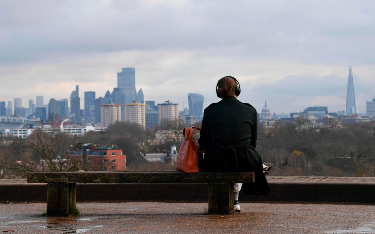 A person sits alone on a bench on the top of Primrose Hill in London on January 12 - JUSTIN TALLIS/AFP