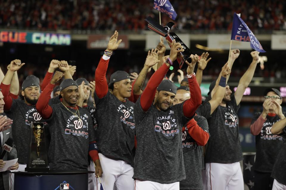 Washington Nationals manager Dave Martinez raises the NLCS trophy after Game 4 of the baseball National League Championship Series against the St. Louis Cardinals Tuesday, Oct. 15, 2019, in Washington. The Nationals won 7-4 to win the series 4-0. (AP Photo/Jeff Roberson)