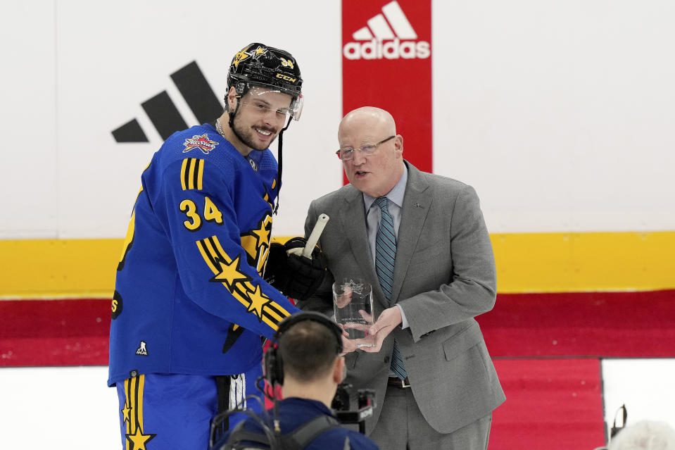 Joe Daly, right, presents NHL All-Star Team Matthews captain forward Auston Matthews (34), of the Toronto Maple Leafs, with the trophy for Most Valuable Player after the team's victory at hockey's NHL All-Star Game in Toronto, Saturday, Feb. 3, 2024. (Nathan Denette/The Canadian Press via AP)