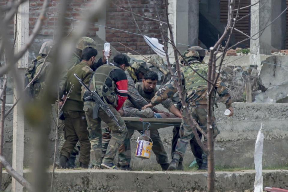 Indian army soldiers carry a wounded colleague on a stretcher towards an ambulance during a gun battle in Chadoora town, about 25 kilometers (15 miles) south of Srinagar, Indian controlled Kashmir, Tuesday, March 28, 2017. The gunbattle began after police and soldiers cordoned off the southern town of Chadoora following a tip that at least one militant was hiding in a house, said Inspector-General Syed Javaid Mujtaba Gillani. As the fighting raged, hundreds of residents chanting anti-India slogans marched near the area in an attempt to help the trapped rebel escape. (AP Photo/Dar Yasin)