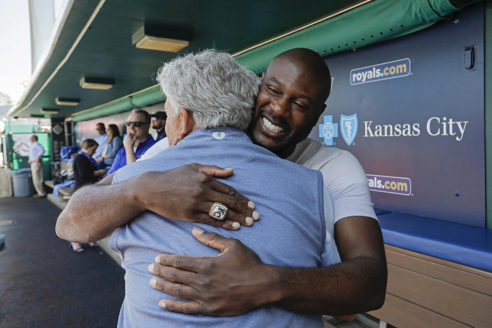 Former Kansas City Royals center fielder Lorenzo Cain, right, hugs his former first base coach Rusty Kuntz, left, before a baseball game against the Oakland Athletics in Kansas City, Mo., Saturday, May 6, 2023. Cain signed a one-day contract with the team so he could retire as a Royal. (AP Photo/Colin E. Braley)