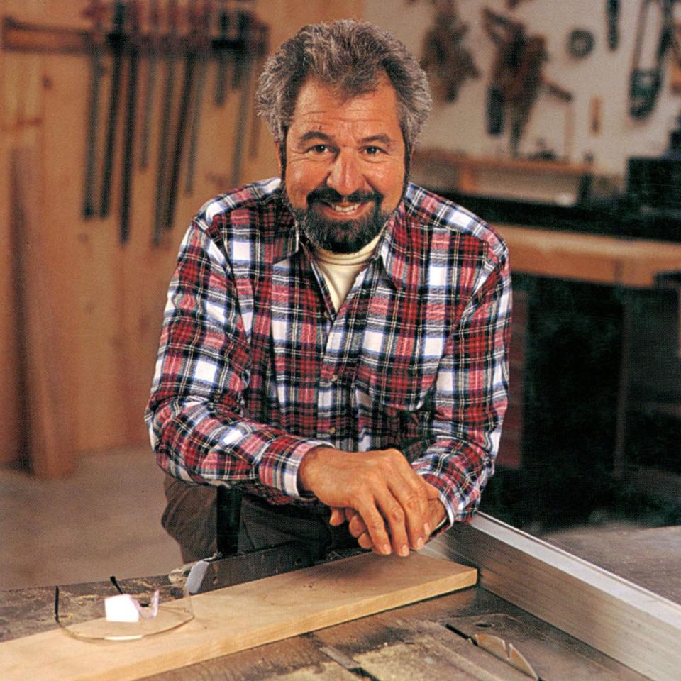 Bob Vila in his workshop wearing a flannel checked shirt.