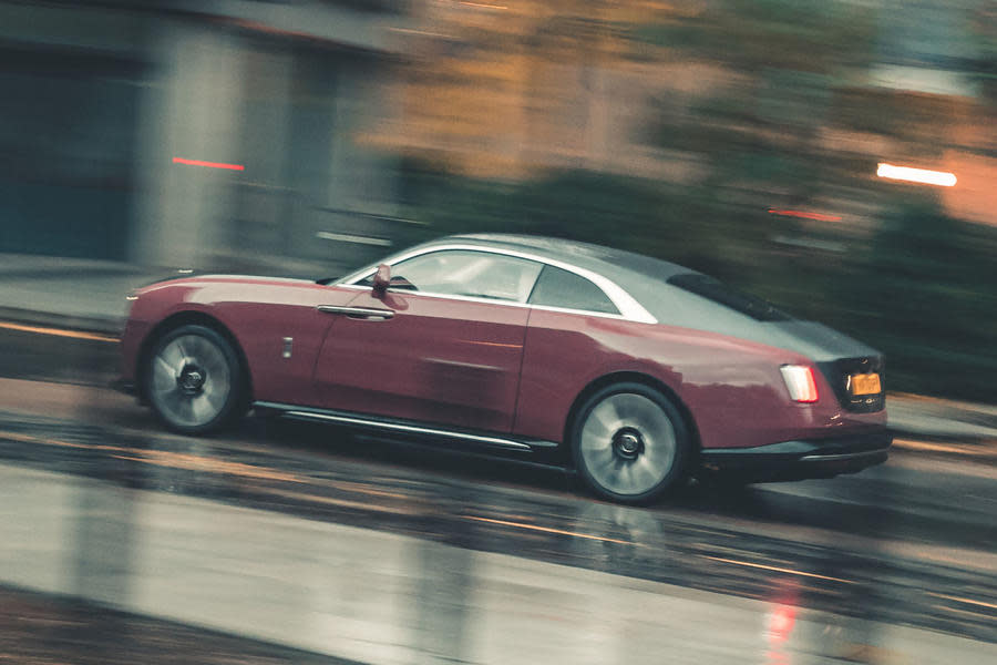 Rolls-Royce Spectre driving through city – rear quarter