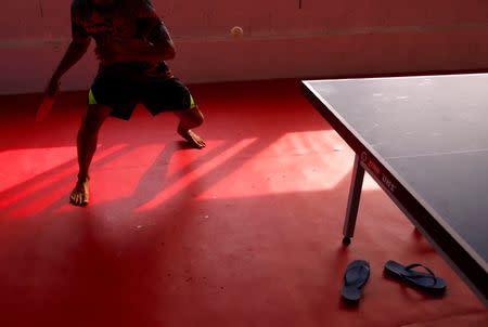 The flip flops of Papua New Guinea table tennis player Gasika Sepa can be seen under a table as he practices at a Beijing-funded facility in central Port Moresby in Papua New Guinea, November 19, 2018. REUTERS/David Gray