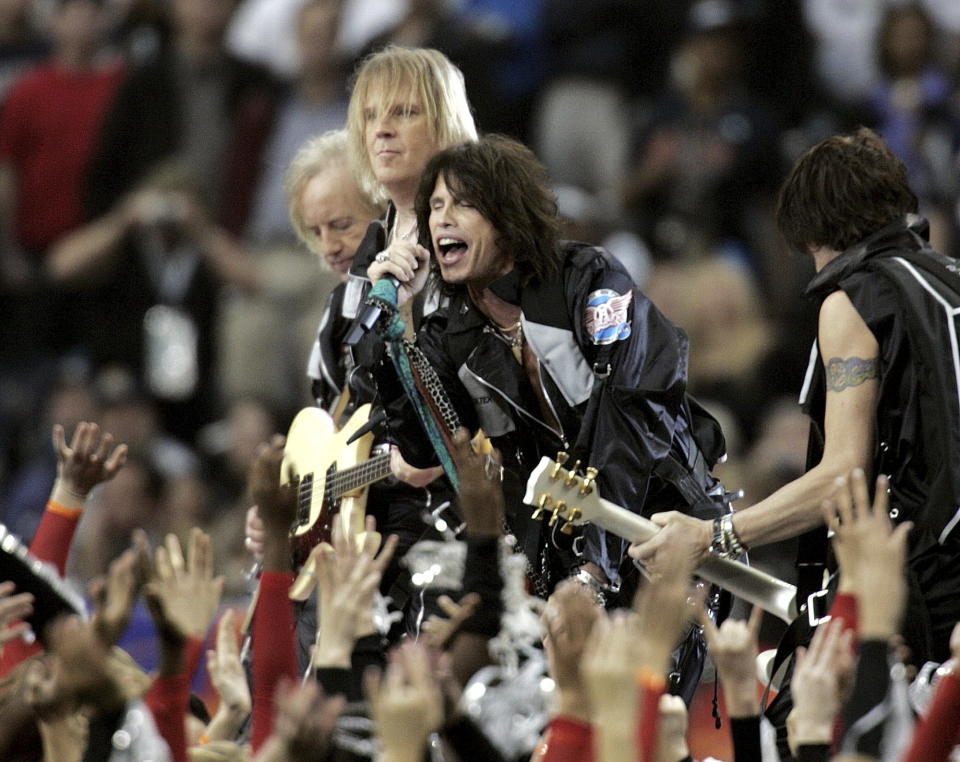 ARCHIVO - Los integrantes de Aerosmith, de izquierda a derecha, Brad Whitford, Tom Hamilton, Steven Tyler y Joe Perry durante su presentación al comienzo del Super Bowl XXXVIII de la NFL el 1 de febrero de 2004, en Houston. En casi seis décadas, el espectáculo de medio tiempo del Super Bowl se ha transformado de un show orientado a la familia con bandas universitarias a ser el escenario más grande del entretenimiento con artistas de primer nivel. (Foto AP/Michael Conroy, archivo)