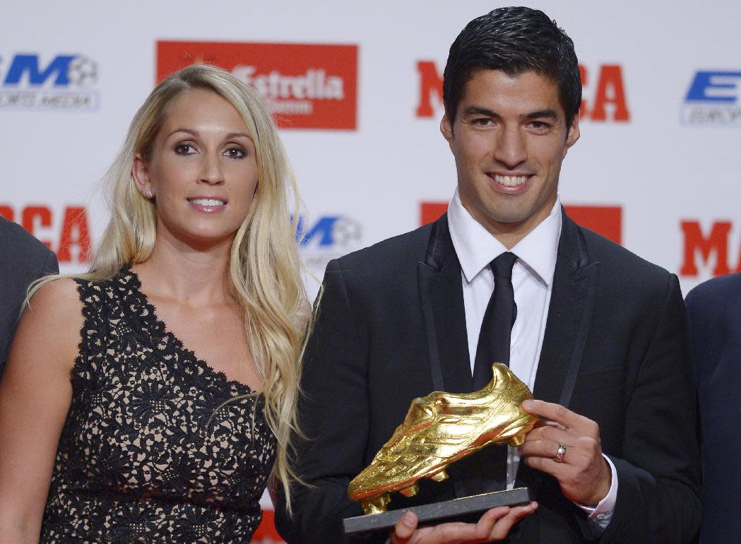 FC Barcelona&#39;s Luis Suarez, from Uruguay, right, poses to the media with his wife Sofia Balbi after receiving the Golden Boot award for scoring the most goals in Europe&#39;s domestic leagues last season shared with Cristiano Ronaldo in Barcelona, Spain, Wednesday, Oct. 15, 2014. (AP Photo/Manu Fernandez)