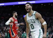 Jayson Tatum (0) de los Celtics de Boston tras completar una volcada ante los Pelicans de Nueva Orleáns, el lunes 17 de enero de 2022. (AP Foto/Mary Schwalm)