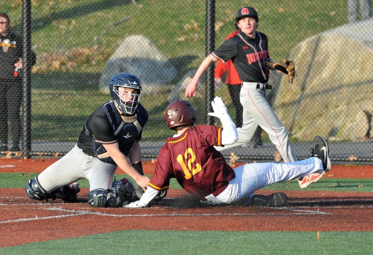 North Quincy catcher Max Gaudiano, left, slaps the tag on Weymouth's Alex Valentin, right, during high school baseball at Libby Field in Weymouth, Tuesday, April 4, 2023.