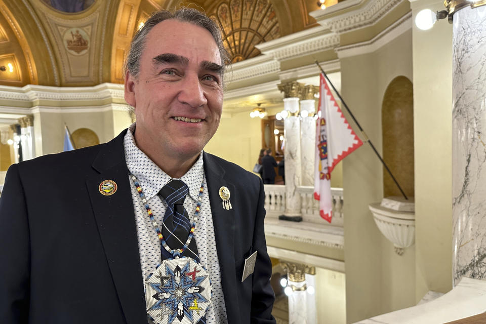 Democratic South Dakota Sen. Shawn Bordeaux stands inside the state Capitol, Feb. 21, 2024, in Pierre, S.D. The Rosebud Sioux Tribe's flag hangs in the background at right. Bordeaux has condemned comments by South Dakota Republican Gov. Kristi Noem that tribal leaders are "personally benefiting" from drug cartels she's said are operating on reservations. Bordeaux is a former Rosebud tribal councilman. (AP Photo/Jack Dura)