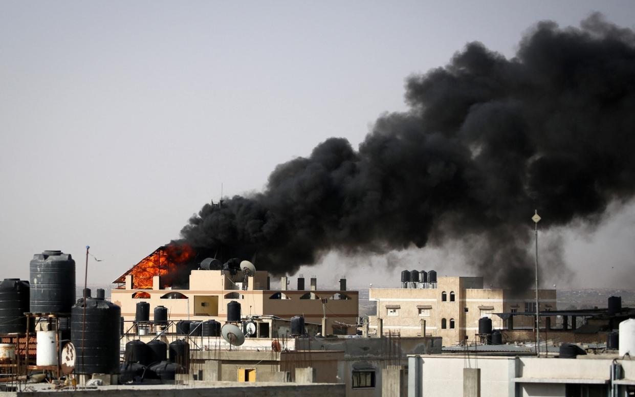 Thick, black smoke rises from a fire in a building caused by Israeli bombardment in Rafah in the southern Gaza Strip on May 10, 2024