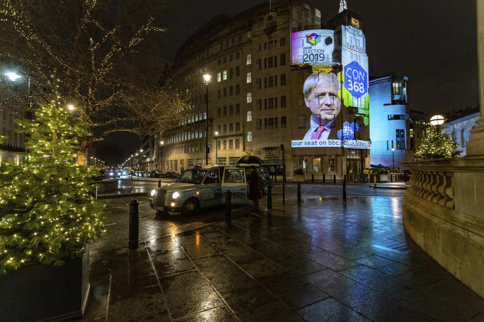 The results of an exit poll are projected onto the outside of Broadcasting House in London, just after voting closed for the 2019 General Election, Thursday, Dec. 12, 2019. An exit poll in Britain’s election projects that Prime Minister Boris Johnson’s Conservative Party likely will win a majority of seats in Parliament. That outcome would allow Johnson to fulfill his plan to take the U.K. out of the European Union next month. (AP Photo/Vudi Xhymshiti)