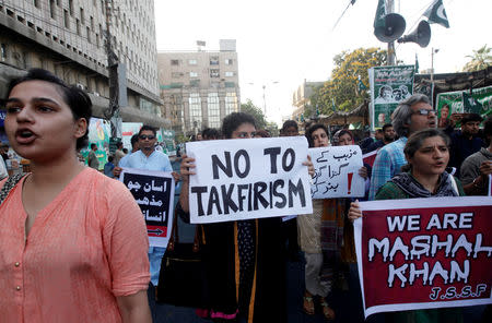 FILE PHOTO: People hold signs as they chant slogans to condemn the killing of Mashal Khan, student of Abdul Wali Khan University after he was accused of blasphemy, during a protest in Karachi, Pakistan, April 22, 2017. REUTERS/Akhtar Soomro/File Photo