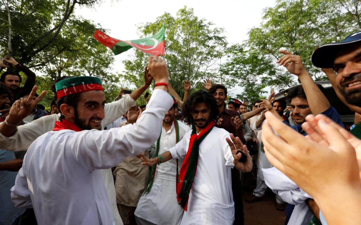 Khan's supporters celebrate outside his residence in Islamabad after the former cricketer declared victory - REUTERS