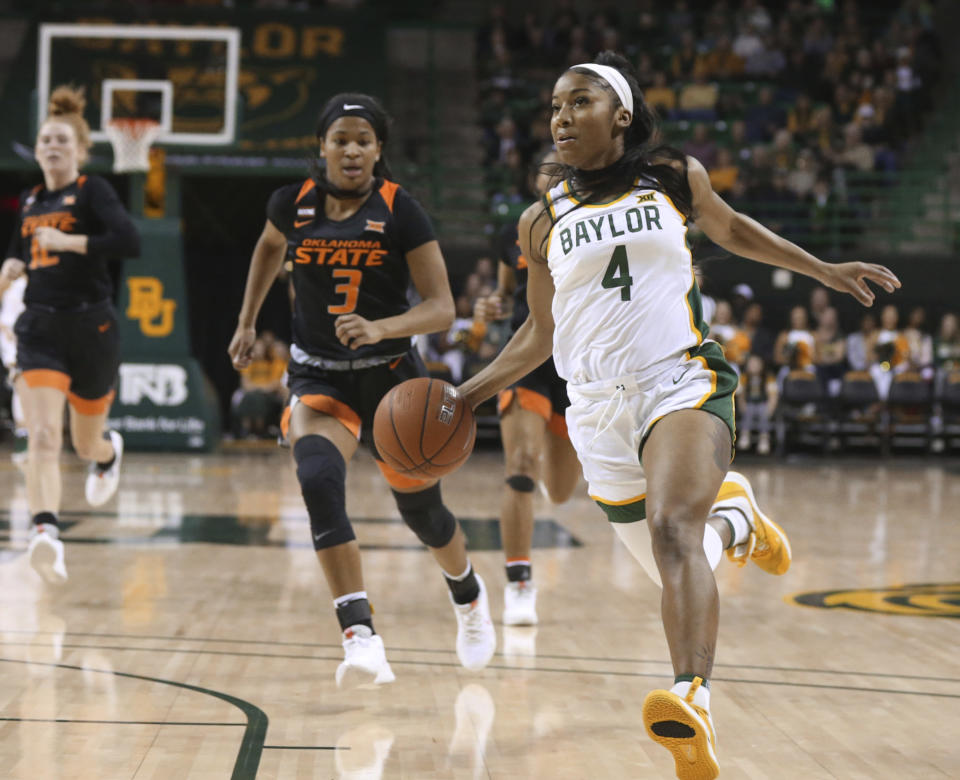 CORRECTS DATE Baylor guard Te'a Cooper drives to the basket past Oklahoma State guard Micah Dennis, left, on a fast break in the first half of an NCAA college basketball game, Sunday, Jan. 12, 2020, in Waco, Texas. (Rod Aydelotte/Waco Tribune Herald via AP)