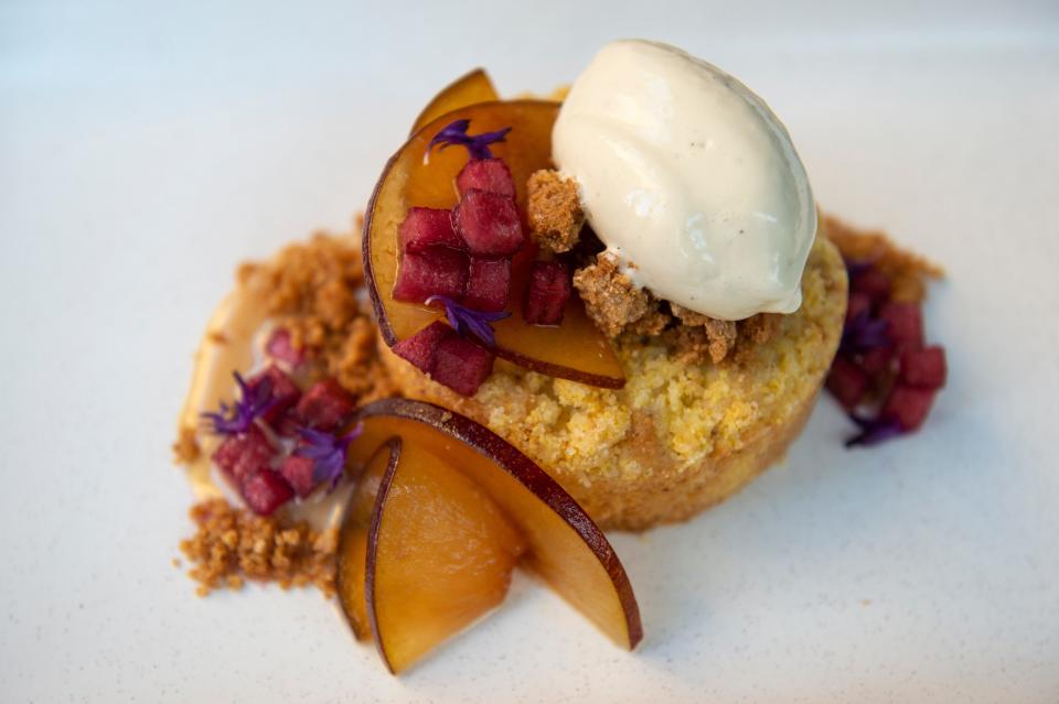 Cornmeal cake topped with cardamom plums, concord honeycrisp apples, caramelized milk jam and ice cream made with ras el hangout, a spice mix containing cloves, lavender and peppercorn among others, at Khora in Downtown Cincinnati on Friday, Nov. 6, 2020. 