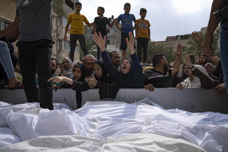 Relatives mourn people killed in an Israeli air strike in Gaza City on Monday, Oct. 9, 2023. Israel's military battled to drive Hamas fighters out of southern towns and seal its borders Monday as it pounded the Gaza Strip. (AP Photo/Fatima Shbair)