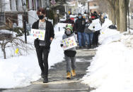 Nicklas Bare, 16, left, and his brother Joshua,11, of Warren, Mich., walk north on Wayburn St. during the walking rally to protest hate and racism, Sunday, Feb. 21, 2021 in Grosse Pointe Park, Mich., following a white resident's display of a Ku Klux Klan flag in a side window facing their Black neighbor's home. JeDonna Dinges, 57, of Grosse Pointe Park, said the klan flag was hanging next door in a window directly across from her dining room. The incident occurred two weeks ago. (Clarence Tabb, Jr./Detroit News via AP)