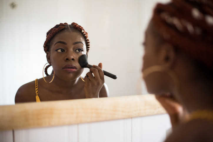 A woman putting on makeup