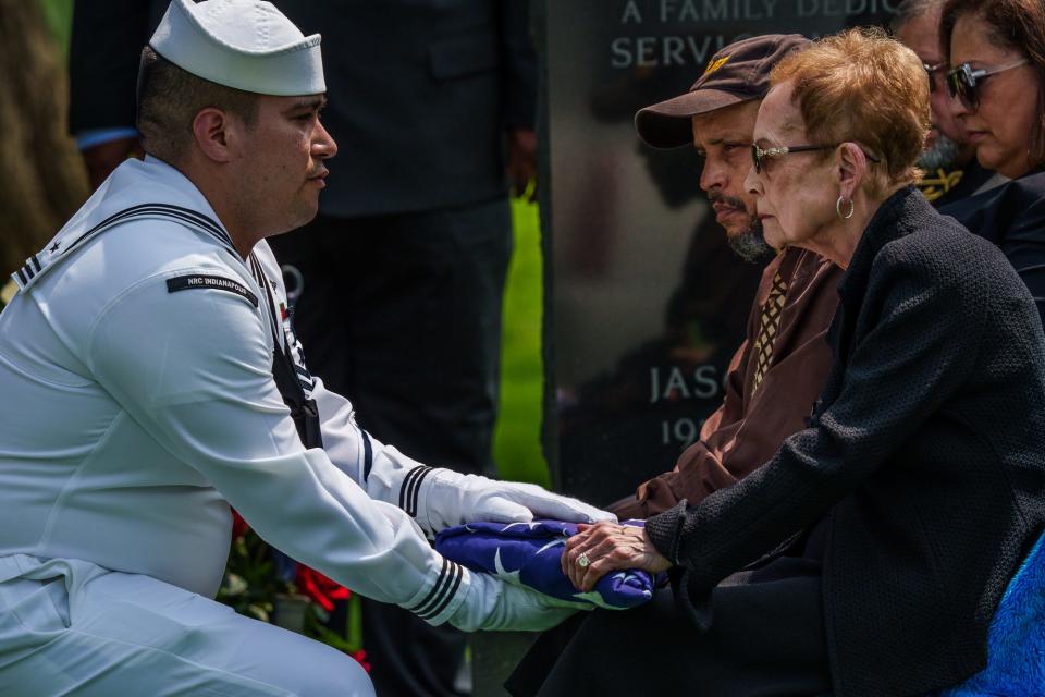 A member of the U.S. Navy hands a burial flag to Mercedes Anderson, wife of Frank J. Anderson, a former U.S. marshal and first Black law enforcement officer elected Marion County sheriff, during a funeral ceremony at Crown Hill Cemetery on Wednesday, May 11, 2022.