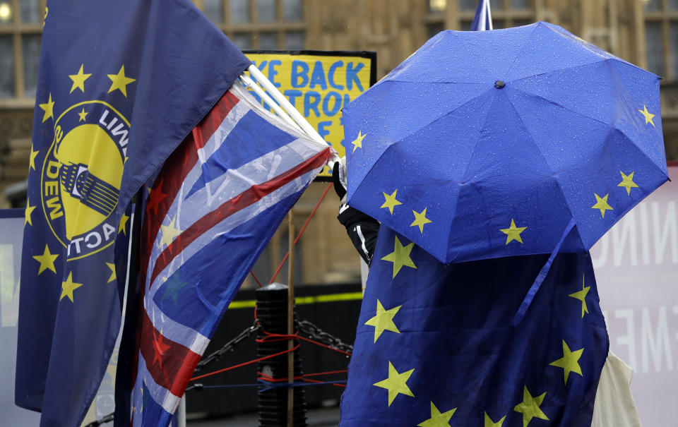 An anti-Brexit demonstrator shelters under an umbrella in the pattern of the European Union flag outside parliament in London, Thursday, Jan. 24, 2019. The European Union's chief Brexit negotiator, Michel Barnier, is rejecting the possibility of putting a time limit on the "backstop" option for the Irish border, saying it would defeat the purpose. (AP Photo/Kirsty Wigglesworth7