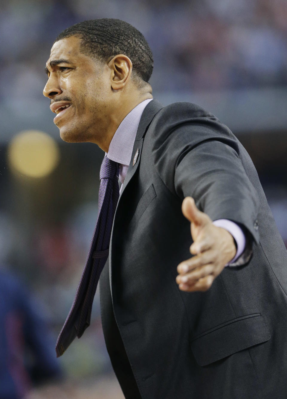 Connecticut head coach Kevin Ollie urges his team on during the first half of the NCAA Final Four tournament college basketball semifinal game against Florida Saturday, April 5, 2014, in Arlington, Texas. (AP Photo/Eric Gay)