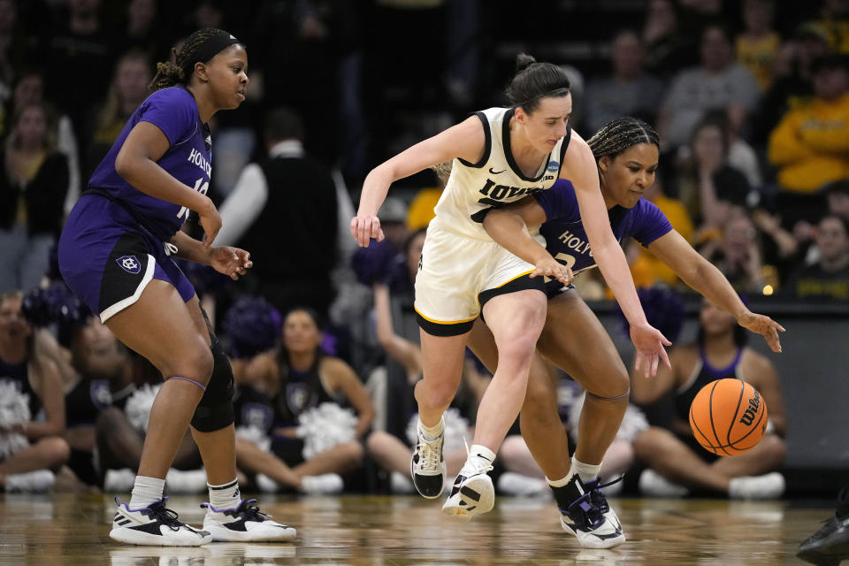 Iowa guard Caitlin Clark (22) steals the ball from Holy Cross guard Simone Foreman (24) in the second half of a first-round college basketball game in the NCAA Tournament, Saturday, March 23, 2024, in Iowa City, Iowa. Iowa won 91-65. (AP Photo/Matthew Putney)