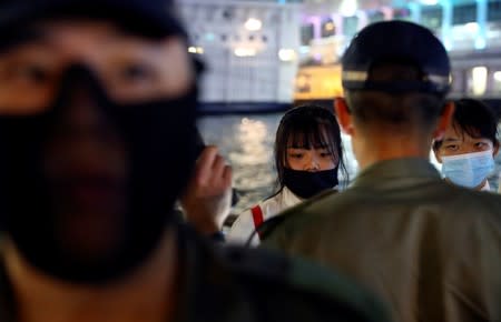 Anti-government protesters stand in front of riot police during a demonstration to celebrate Taiwan's National Day at the Harbour city in Tsim Sha Tsui district, in Hong Kong