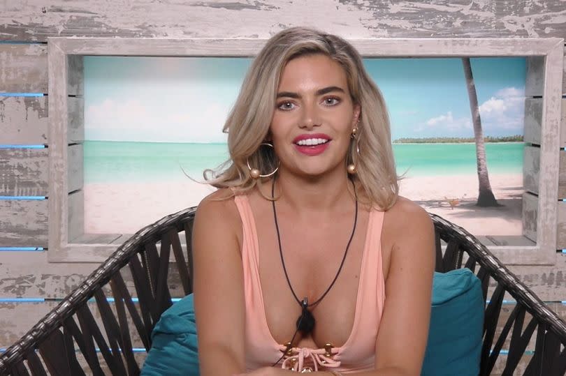 Megan Barton Hanson in the Love Island booth wearing a pink bikini