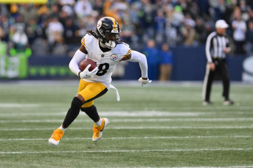 Dec 31, 2023; Seattle, Washington, USA; Pittsburgh Steelers wide receiver Diontae Johnson (18) carries the ball against the Seattle Seahawks during the second half at Lumen Field. Mandatory Credit: Steven Bisig-USA TODAY Sports