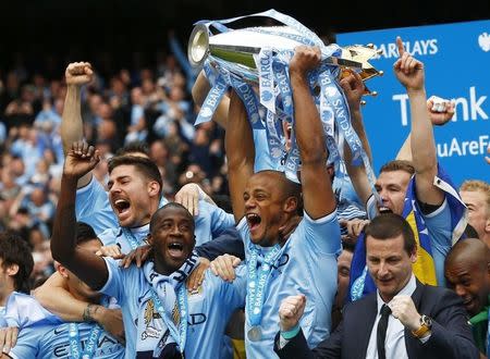 Manchester City's captain Vincent Kompany (C) celebrates after winning the English Premier League trophy following their soccer match against West Ham United at the Etihad Stadium in Manchester, northern England May 11, 2014. REUTERS/Darren Staples