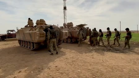 Still image from video shows Syrian rebel fighters near tanks, near Tal Abyad