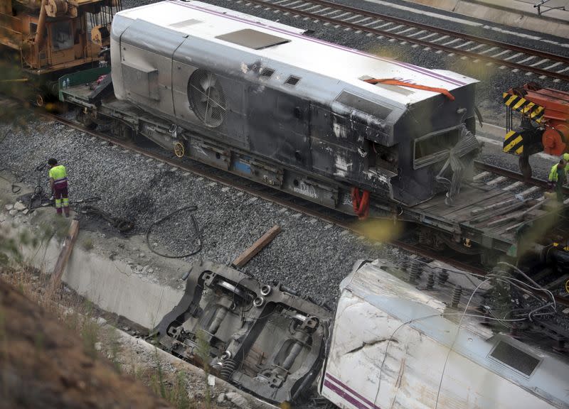 FILE PHOTO: A worker stands beside the wrecked train engine at the site of a train crash in Santiago de Compostela