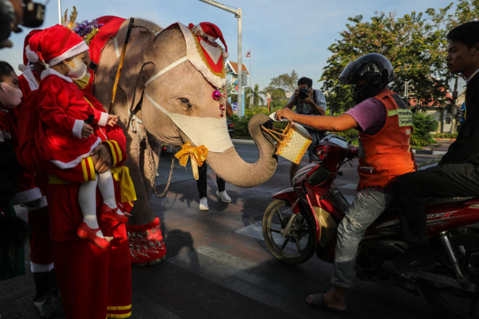 Thai elephants dressed as Santa Claus deliver face masks to motorists on a busy street corner in Phra Nakhon Si Ayutthaya, Thailand on Dec. 23, 2020.<span class="copyright">Lauren DeCicca—Getty Images</span>