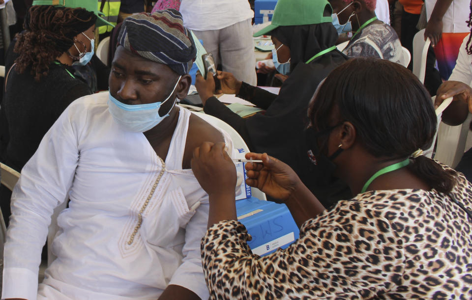 A Nigeria civil servant receives a dose of the AstraZeneca coronavirus vaccine, in Abuja, Nigeria , Wednesday, Dec. 1, 2021. Nigeria has detected its first case of the omicron coronavirus variant in a sample it collected in October, weeks before South Africa alerted the world about the variant last week, the country's national public health institute said Wednesday. (AP Photo/Gbemiga Olamikan)