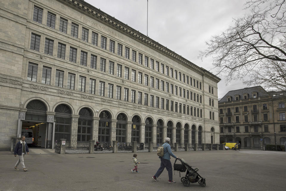 People walk past the facade of the Swiss National Bank, in Zurich, Switzerland, on Thursday, March 23, 2023. (Michael Buholzer/Keystone via AP)