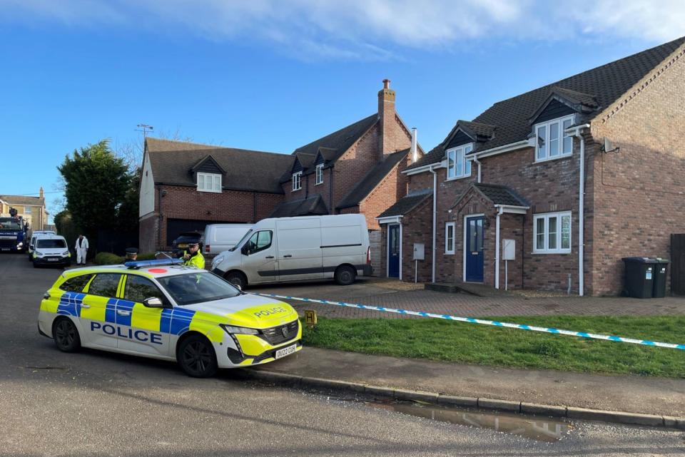 Police at the scene in The Row in Sutton, near Ely, Cambridgeshire, where police found the body of a 57-year-old man who had died from gunshot wounds (PA)